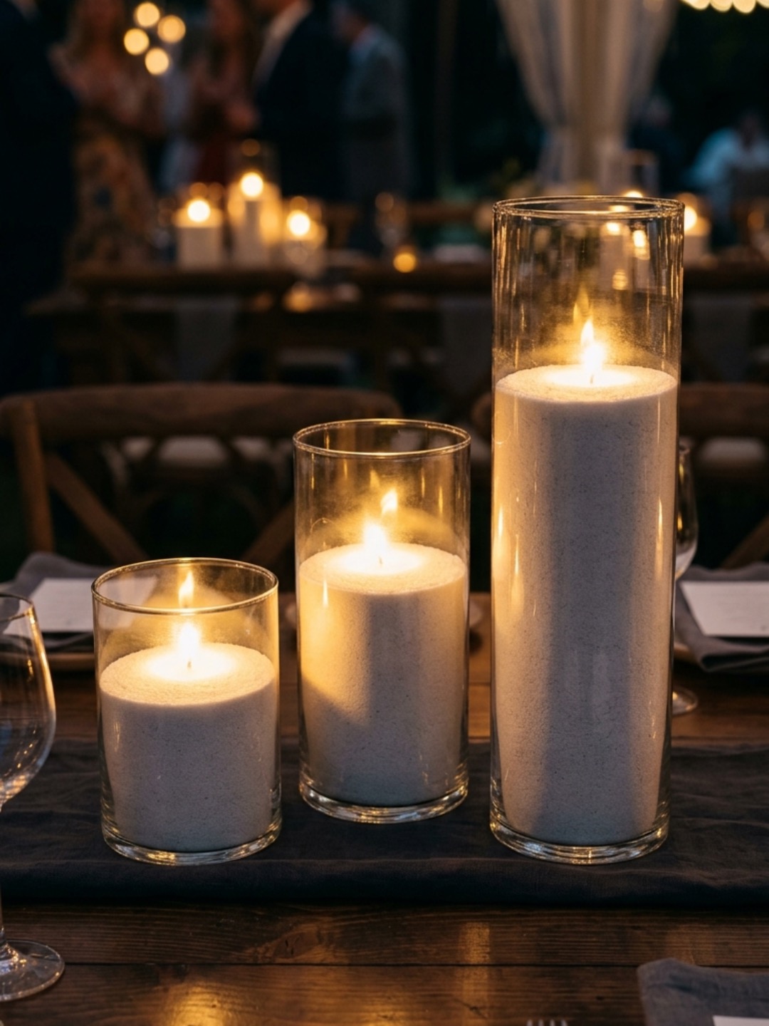 Wedding venue table styling with candles in clear glass vessels